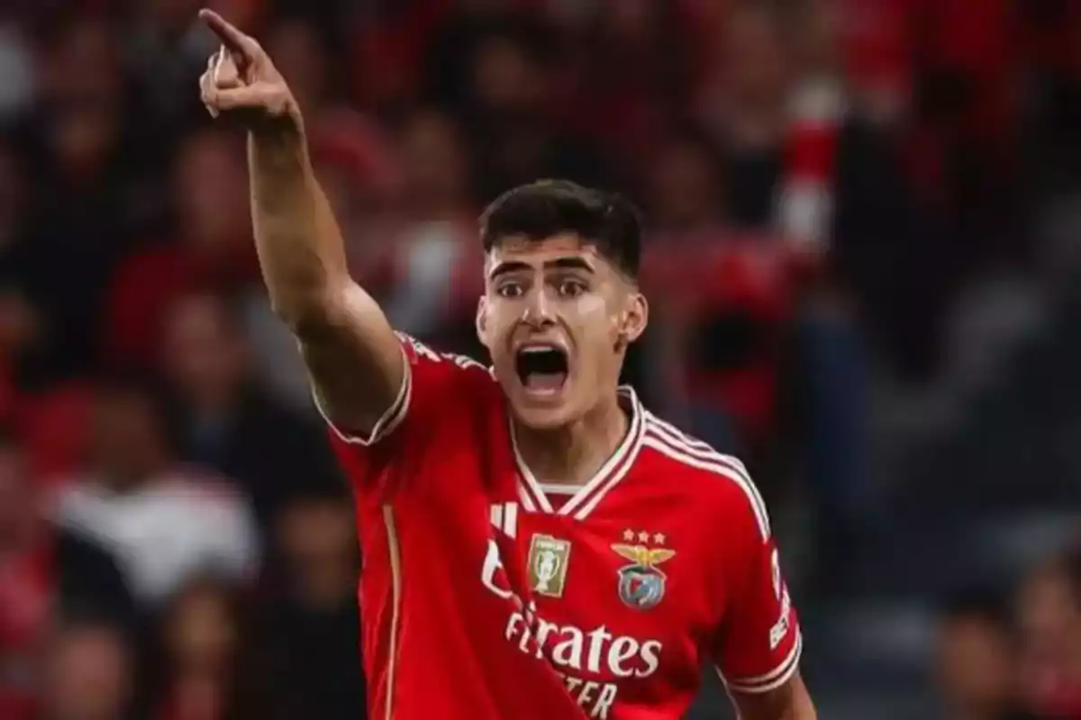 Soccer player in a red Benfica uniform shouts and points with an outstretched arm during a match Soccer player in a red Benfica uniform shouts and points with an outstretched arm during a match