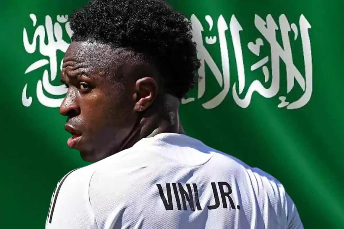 Futbolista con camiseta blanca que dice Vini Jr de espaldas frente a una bandera verde con letras árabes