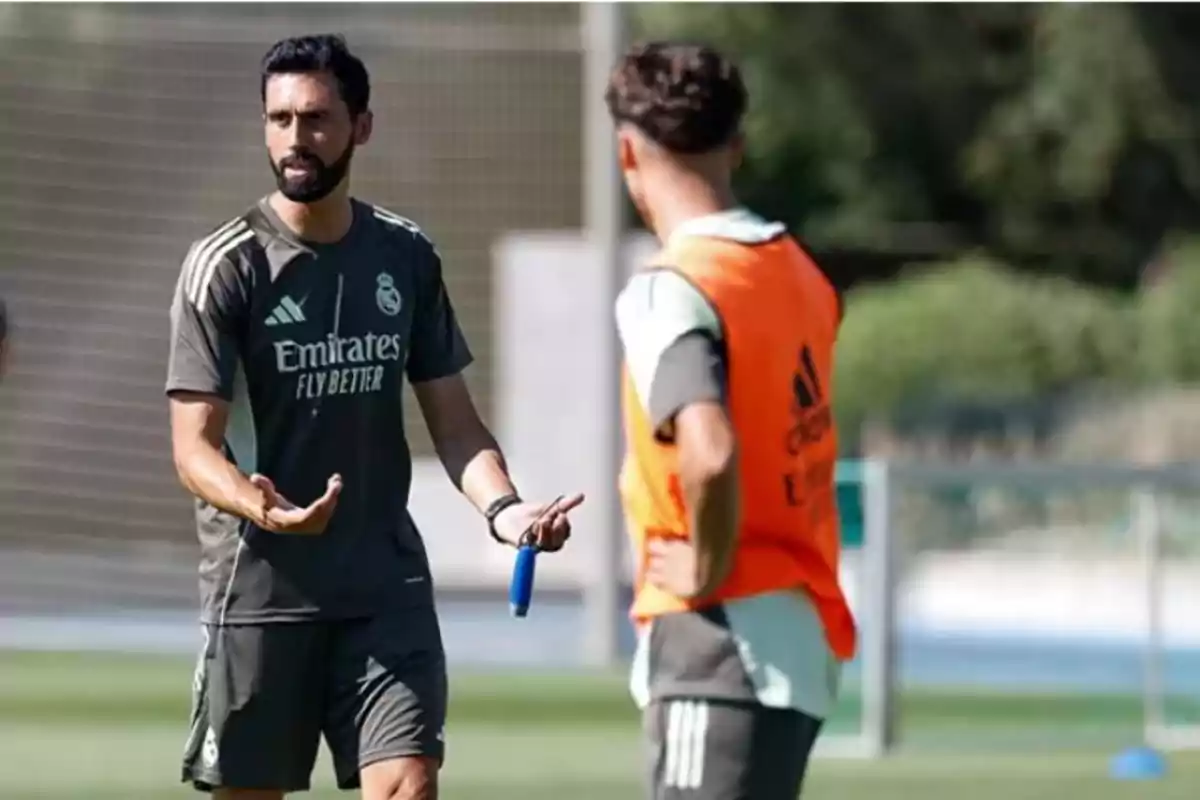 Entrenador de fútbol dando indicaciones a un jugador durante una práctica en campo