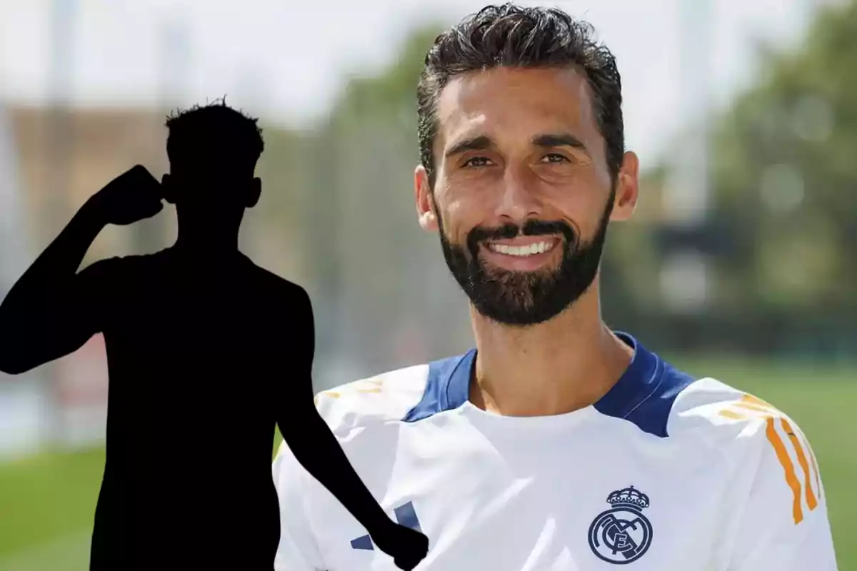 Man wearing a Real Madrid jersey smiles while a black silhouette of a person appears in the foreground