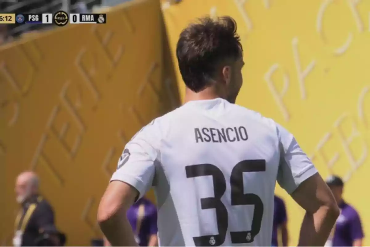 Jugador de fútbol con la camiseta blanca del Real Madrid y el número 35 de espaldas durante un partido contra el PSG, con marcador 1-0 a favor del PSG en la esquina superior izquierda. Jugador de fútbol con la camiseta blanca del Real Madrid y el número 35 de espaldas durante un partido contra el PSG, con marcador 1-0 a favor del PSG en la esquina superior izquierda.