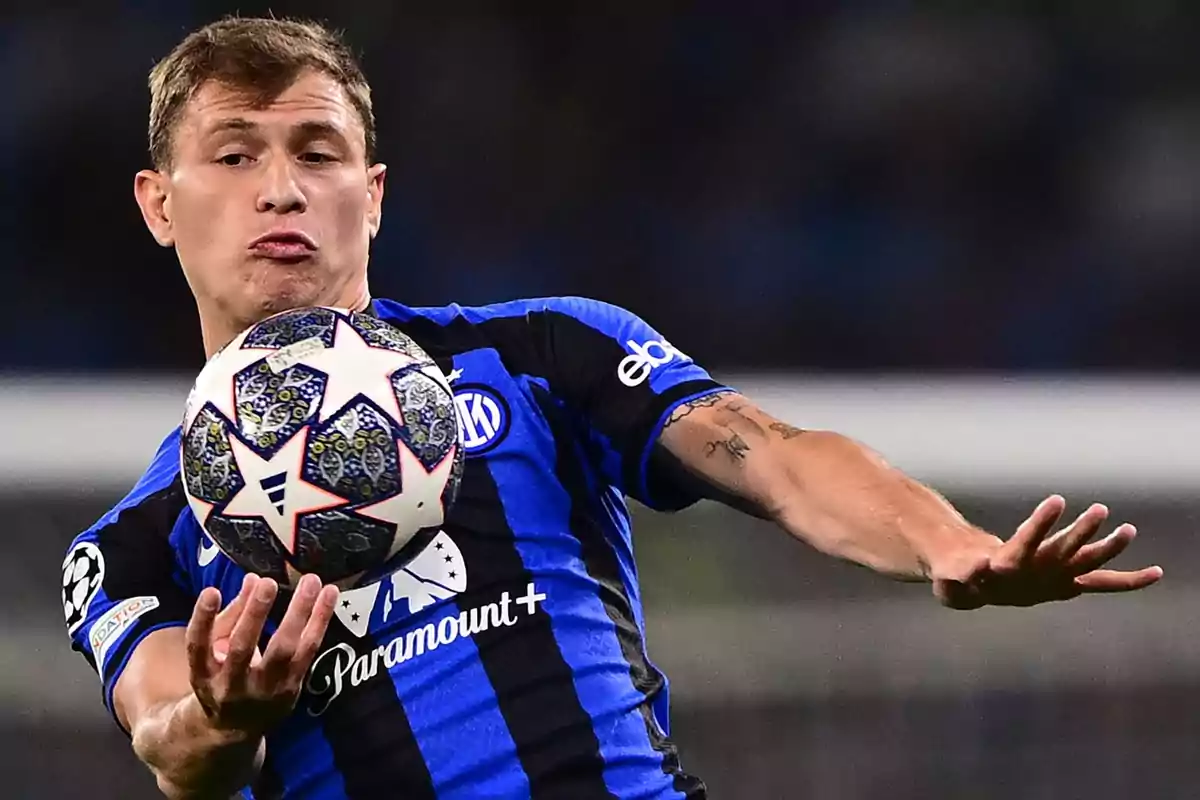 Futbolista con uniforme azul y negro controlando un balón durante un partido Futbolista con uniforme azul y negro controlando un balón durante un partido