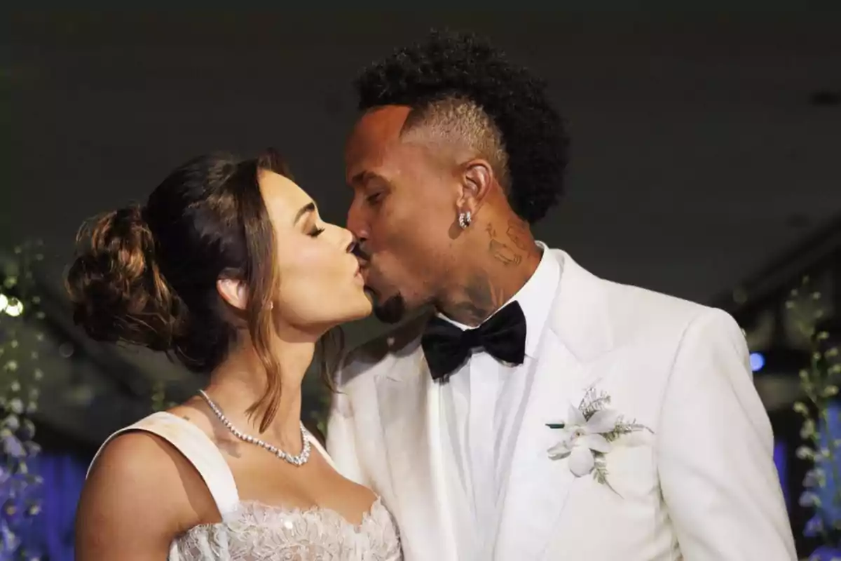 Couple dressed as bride and groom sharing a kiss during their wedding Couple dressed as bride and groom sharing a kiss during their wedding