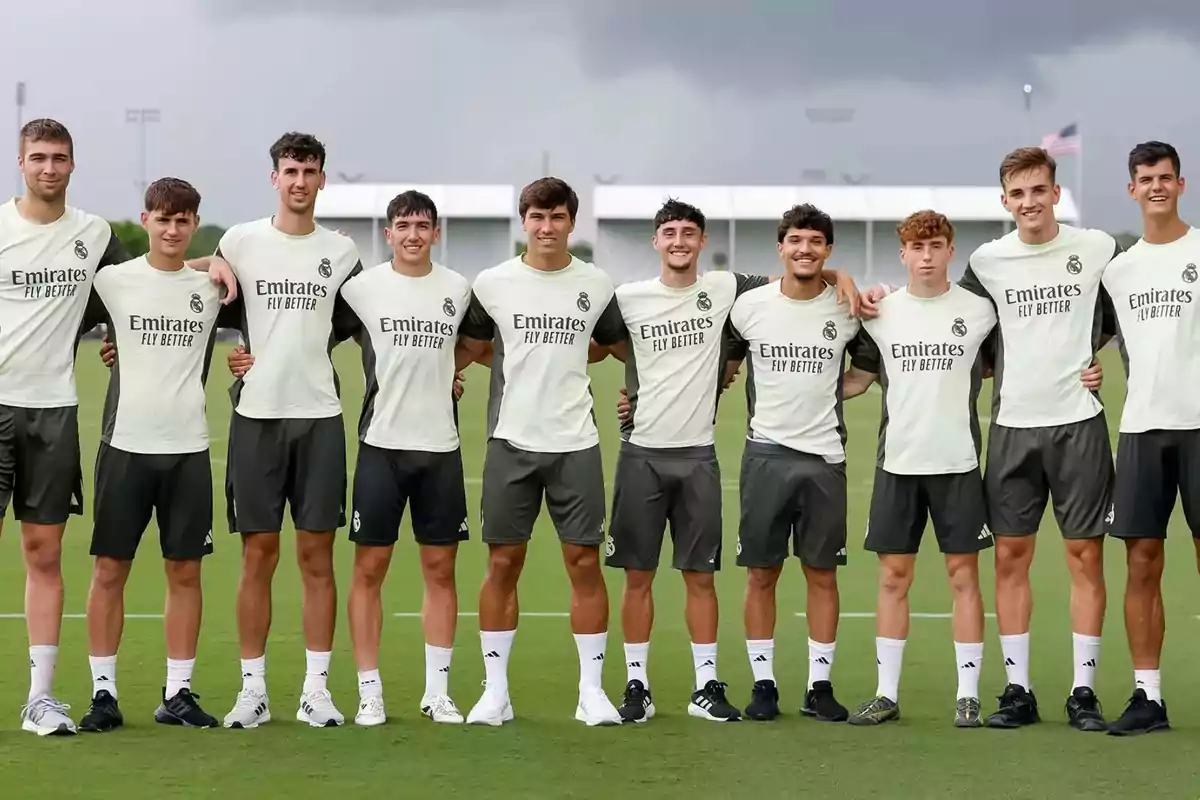 Grupo de jóvenes futbolistas con uniforme de entrenamiento del Real Madrid posando juntos en una cancha de césped