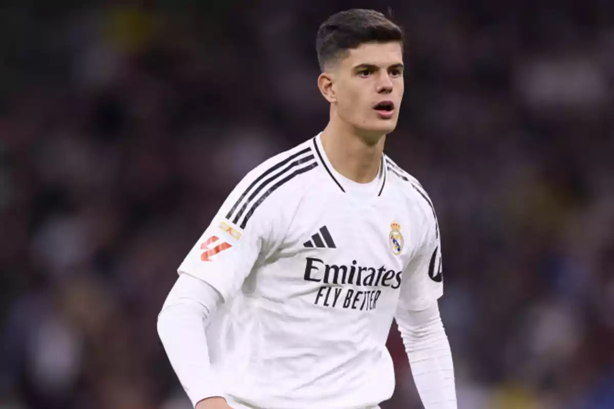 Jugador de fútbol con uniforme blanco del Real Madrid en el campo durante un partido Jugador de fútbol con uniforme blanco del Real Madrid en el campo durante un partido
