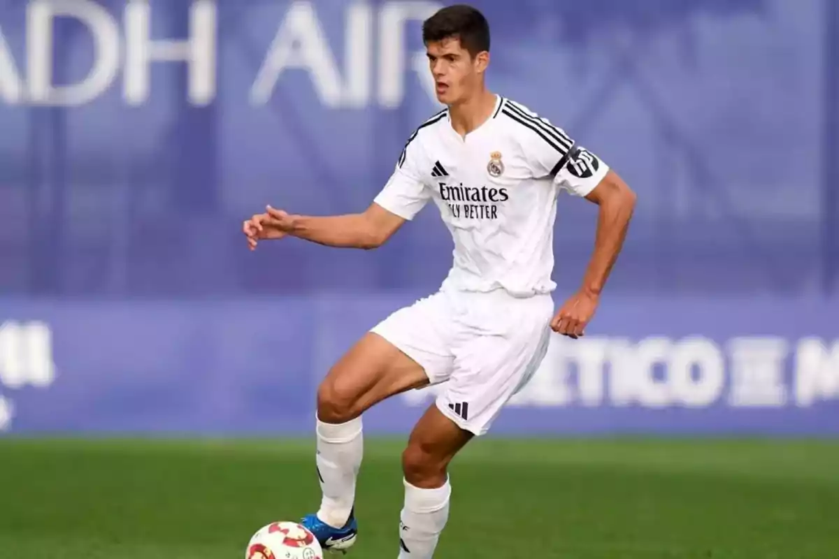 Soccer player in a white Real Madrid uniform controlling the ball on a playing field Soccer player in a white Real Madrid uniform controlling the ball on a playing field