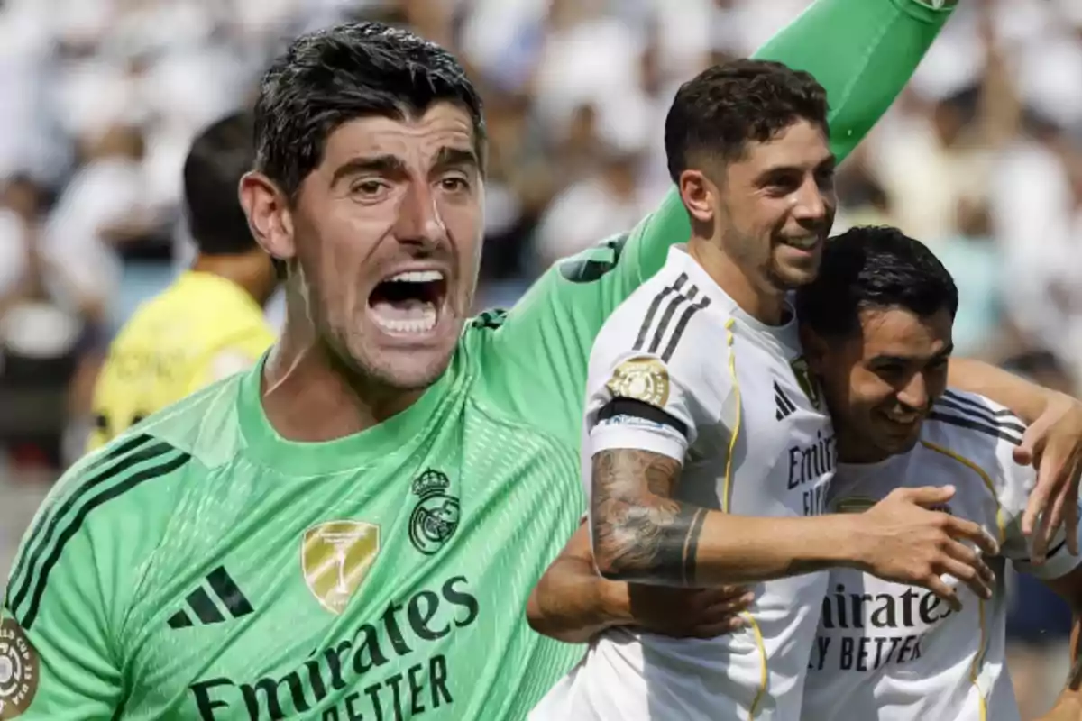 Real Madrid goalkeeper celebrating with two teammates dressed in white uniforms during a soccer match