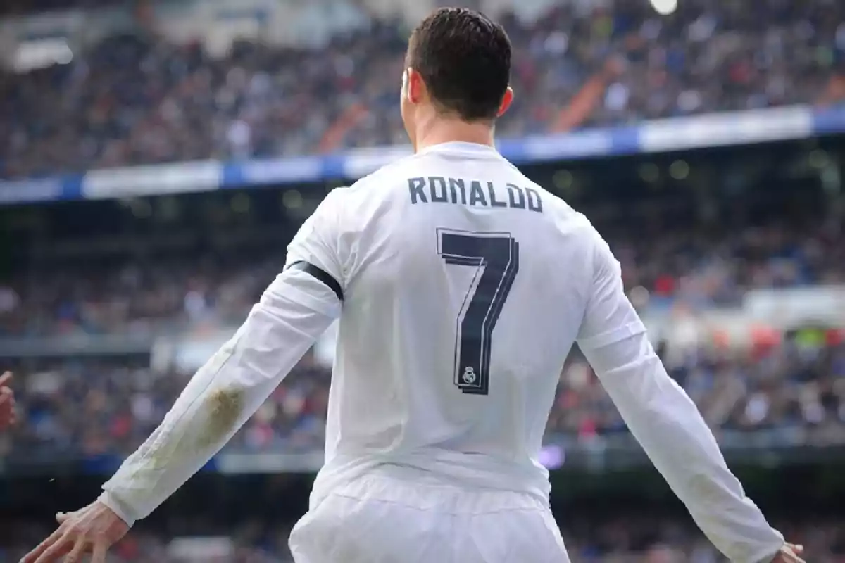 Futbolista con el número 7 y el nombre Ronaldo en la camiseta blanca durante un partido en un estadio lleno de espectadores Futbolista con el número 7 y el nombre Ronaldo en la camiseta blanca durante un partido en un estadio lleno de espectadores