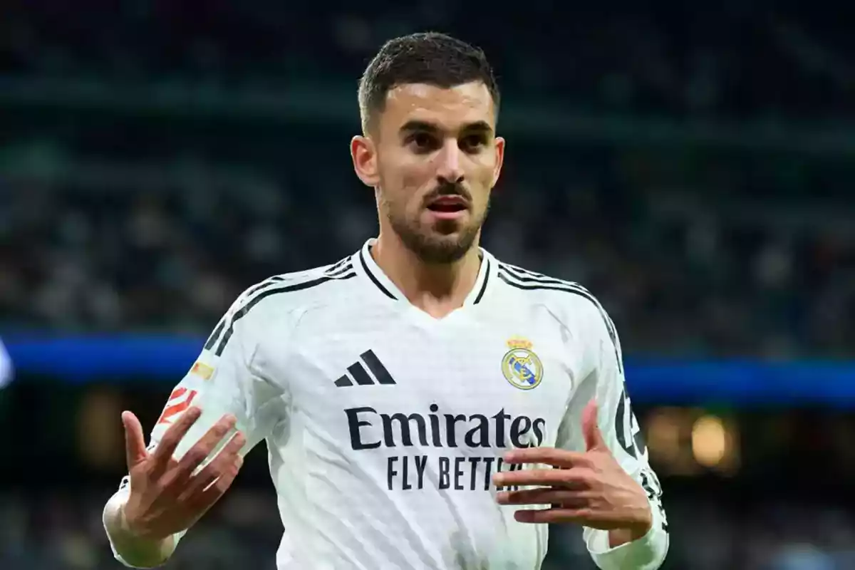 Real Madrid player in a white uniform gesturing during a match at the stadium. Real Madrid player in a white uniform gesturing during a match at the stadium.
