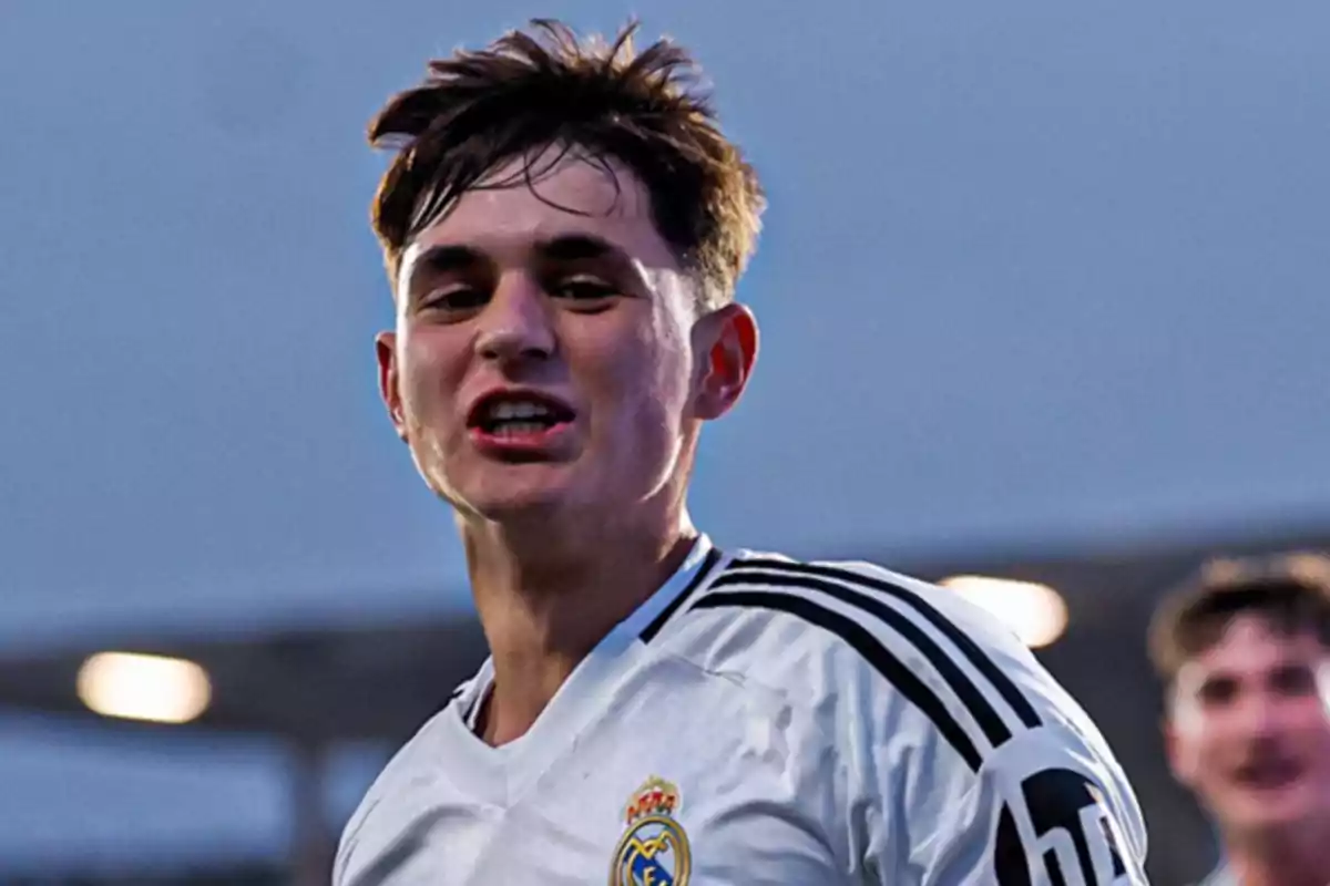 Joven futbolista con camiseta blanca del Real Madrid celebrando en un estadio al aire libre Joven futbolista con camiseta blanca del Real Madrid celebrando en un estadio al aire libre