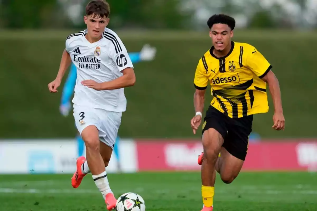 Dos futbolistas jóvenes compiten por el balón durante un partido entre Real Madrid y Borussia Dortmund en un campo de césped Dos futbolistas jóvenes compiten por el balón durante un partido entre Real Madrid y Borussia Dortmund en un campo de césped