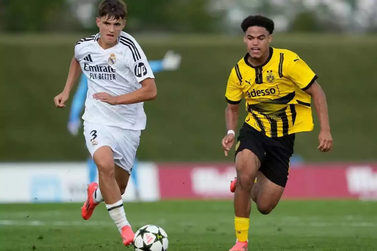 Dos futbolistas jóvenes compiten por el balón durante un partido entre Real Madrid y Borussia Dortmund en un campo de césped