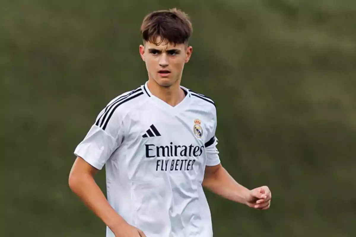 Joven futbolista con uniforme blanco del Real Madrid en el campo de juego Joven futbolista con uniforme blanco del Real Madrid en el campo de juego