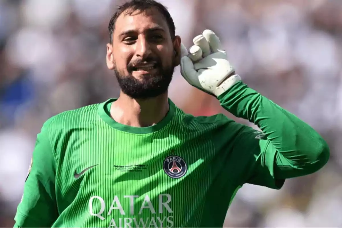 Portero del PSG con uniforme verde celebrando y llevándose la mano a la oreja en señal de escuchar al público Portero del PSG con uniforme verde celebrando y llevándose la mano a la oreja en señal de escuchar al público