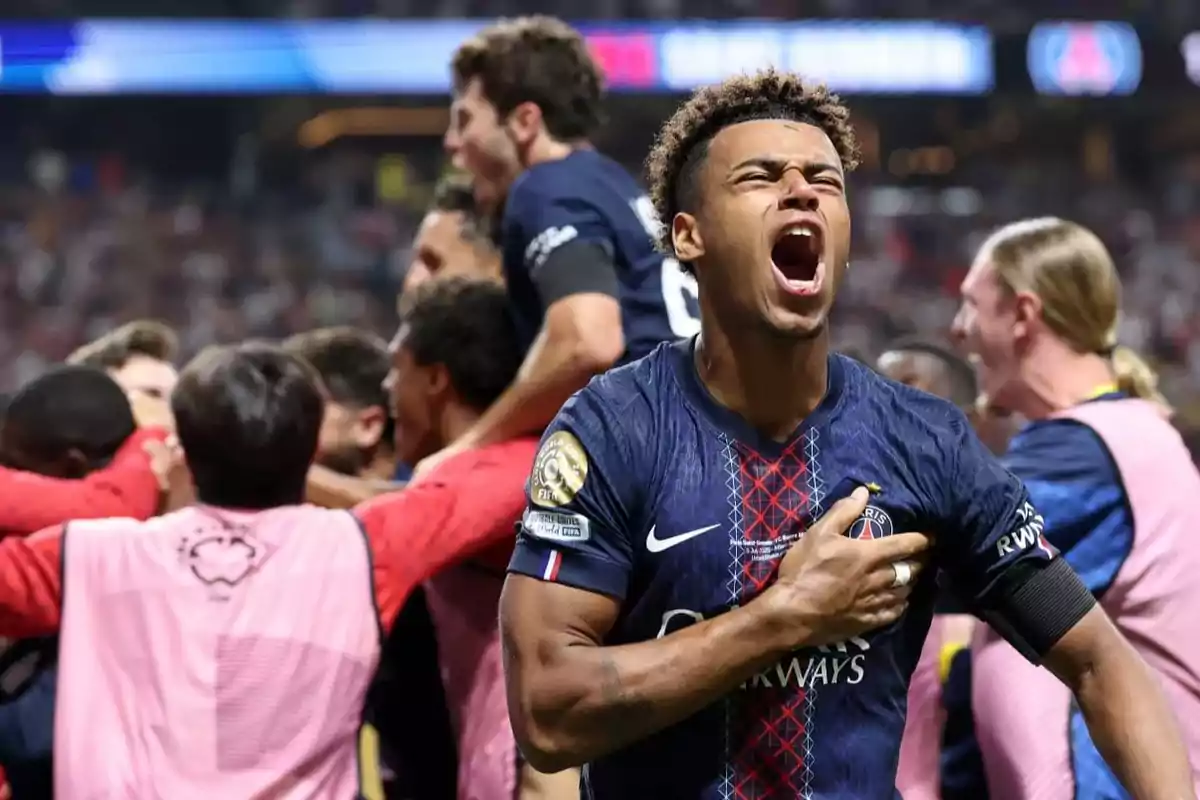 Soccer player celebrating passionately while his team hugs in the background during an important match Soccer player celebrating passionately while his team hugs in the background during an important match