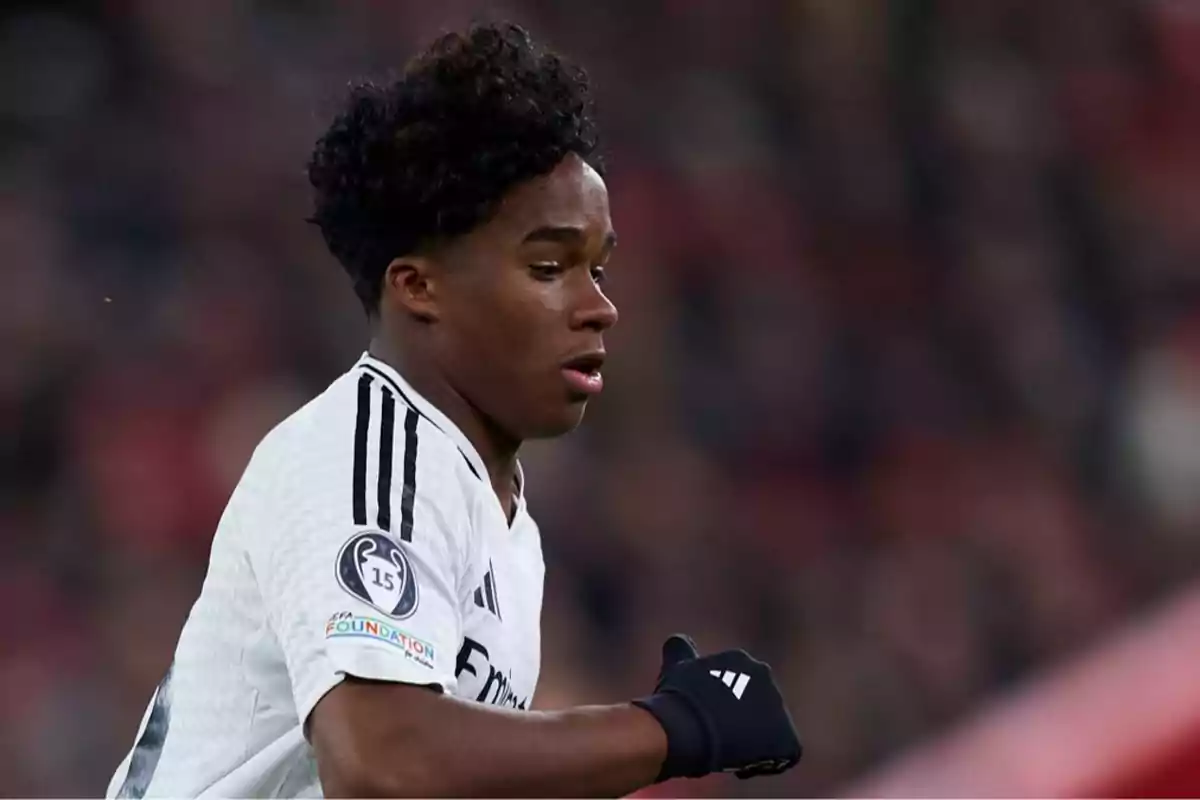 Joven futbolista con uniforme blanco y guantes negros durante un partido Joven futbolista con uniforme blanco y guantes negros durante un partido