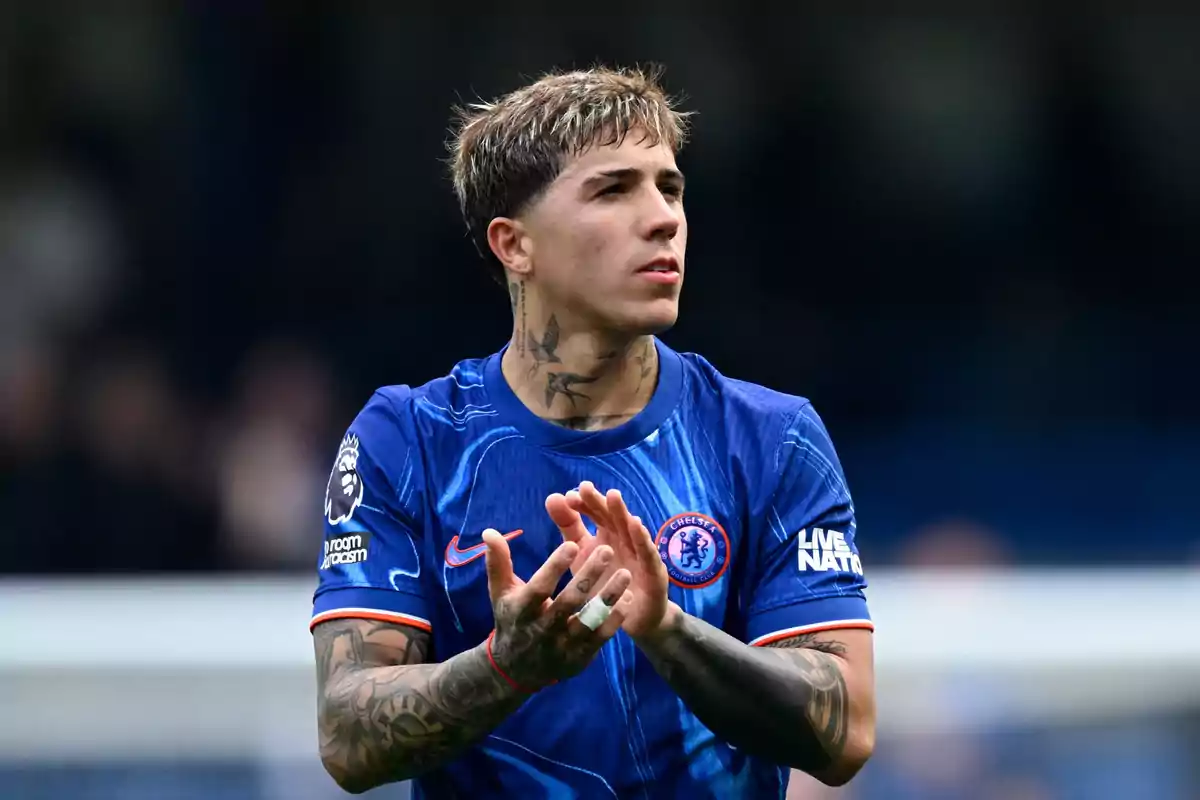 Soccer player with tattoos wearing Chelsea’s blue uniform applauding on the field. Soccer player with tattoos wearing Chelsea’s blue uniform applauding on the field.
