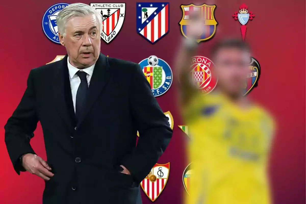 Soccer coach in a dark suit in front of several LaLiga team crests and a blurred player in the foreground