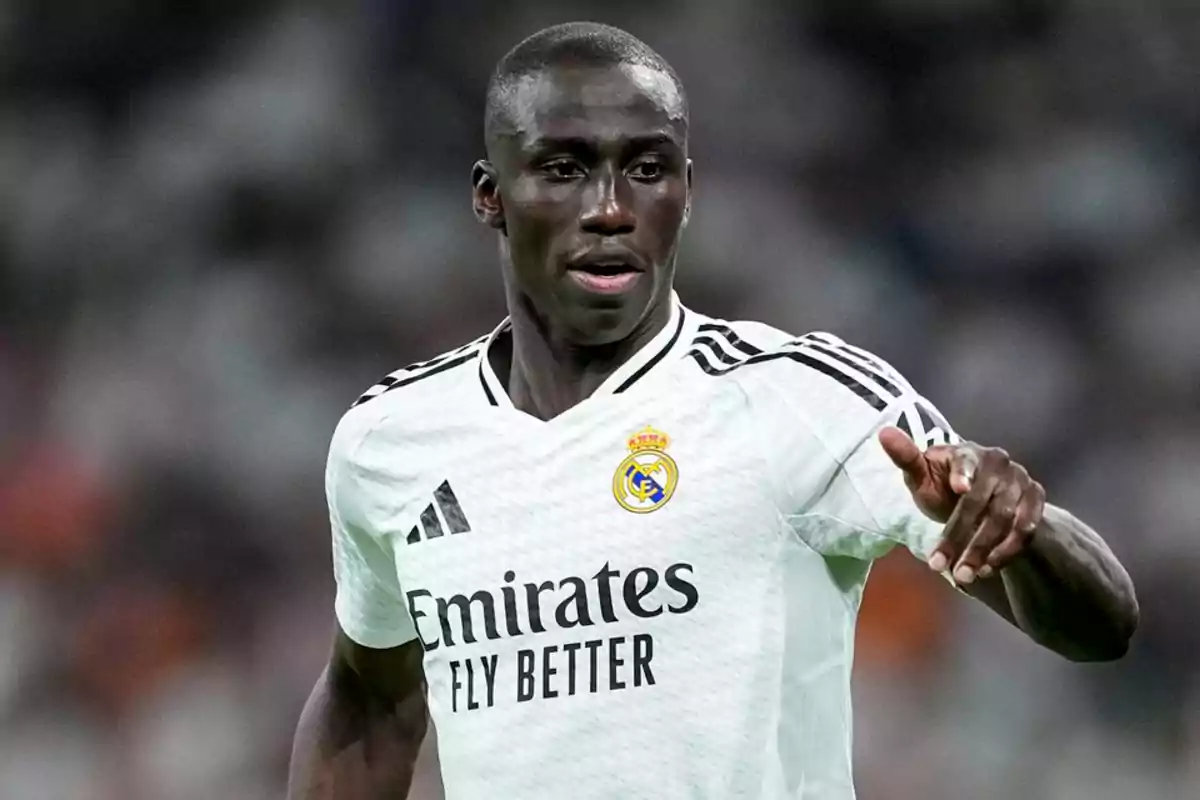Real Madrid player in a white uniform during a match Real Madrid player in a white uniform during a match