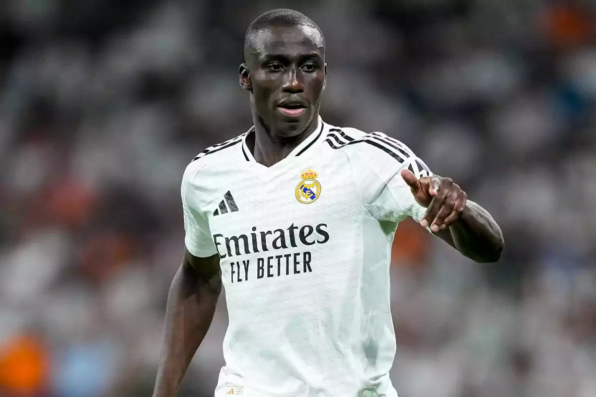 Futbolista del Real Madrid con uniforme blanco durante un partido señalando con la mano derecha Futbolista del Real Madrid con uniforme blanco durante un partido señalando con la mano derecha