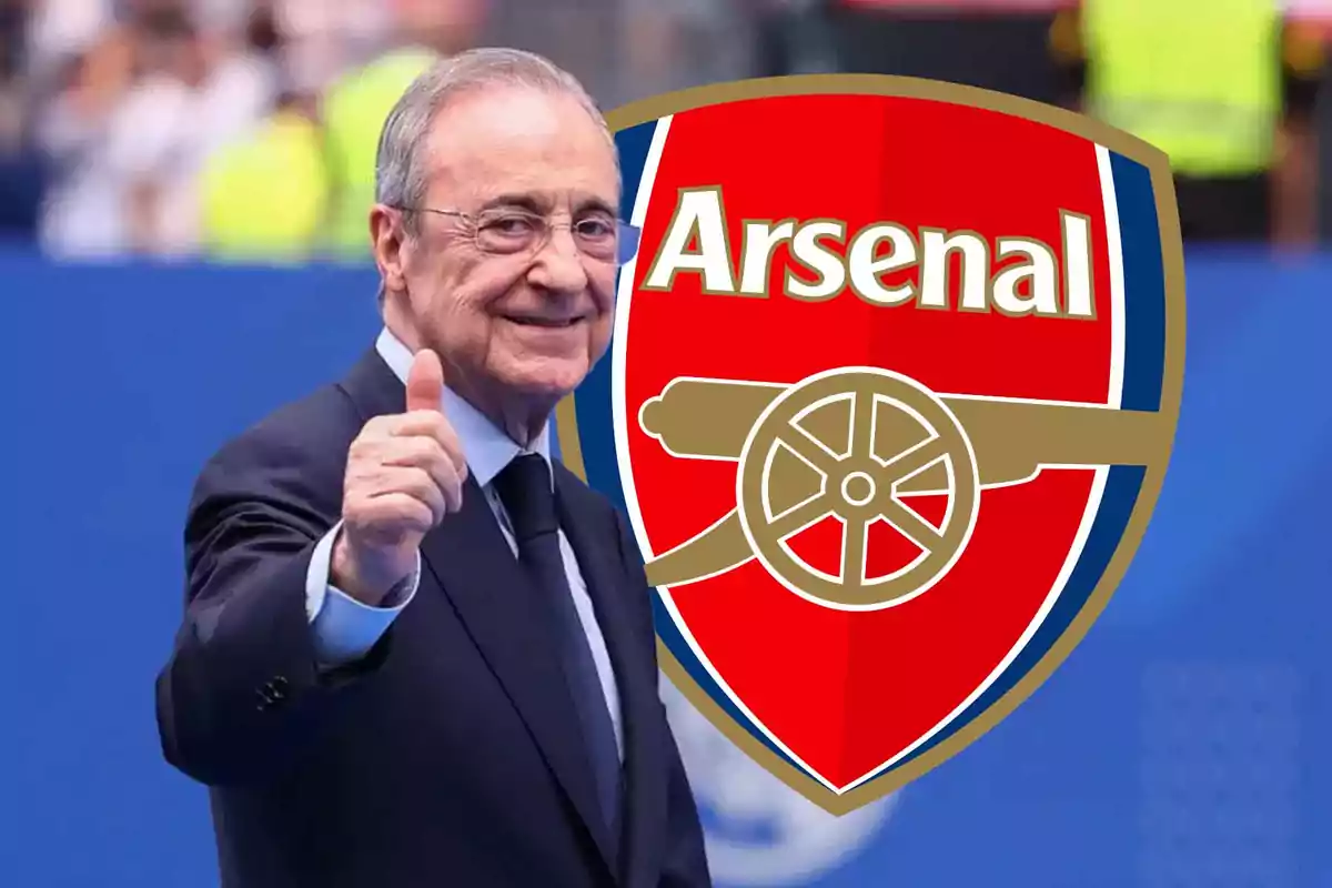Hombre de traje sonriente levantando el pulgar con el escudo del Arsenal de fondo