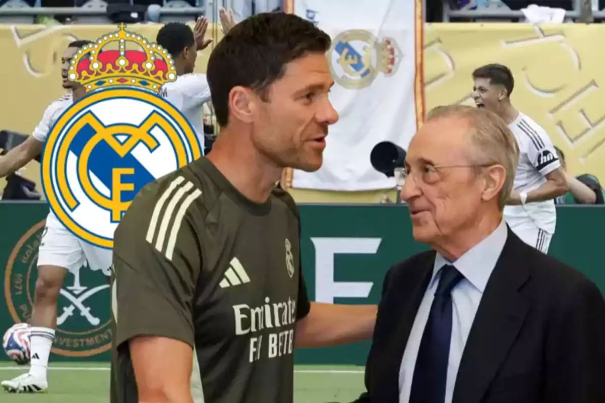 Two men are talking in the foreground with the Real Madrid crest and celebrating players in the background.