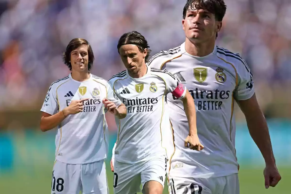 Tres futbolistas del Real Madrid con uniforme blanco posan y corren en un campo de fútbol con fondo desenfocado