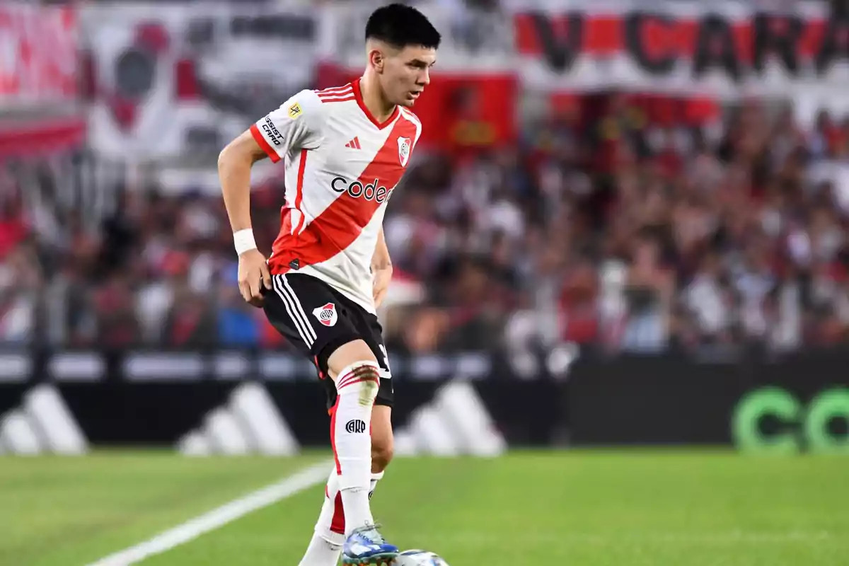 River Plate player controlling the ball during a match in the stadium with spectators in the background River Plate player controlling the ball during a match in the stadium with spectators in the background