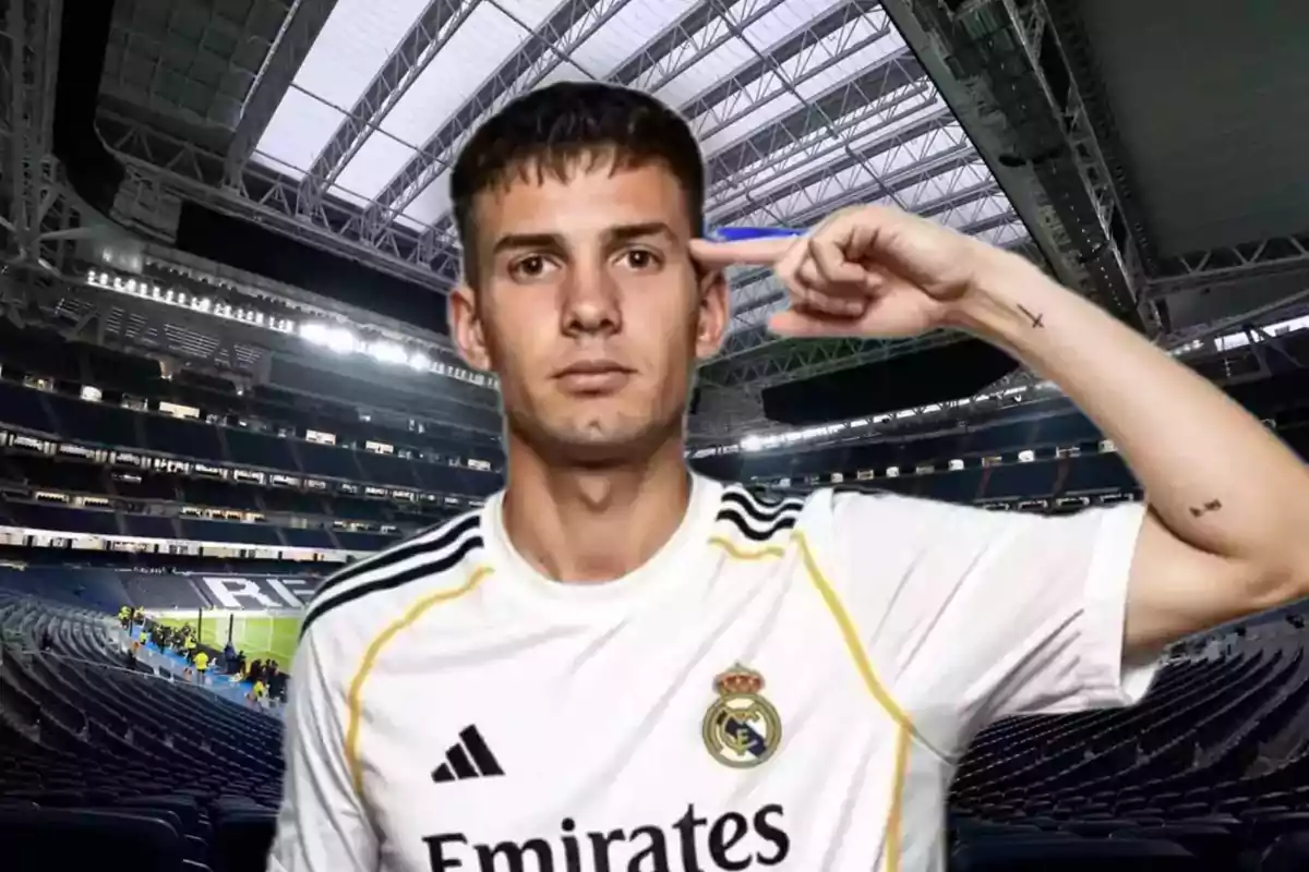 Jugador del Real Madrid con el uniforme blanco haciendo un gesto con la mano en la cabeza dentro de un estadio de fútbol moderno y techado