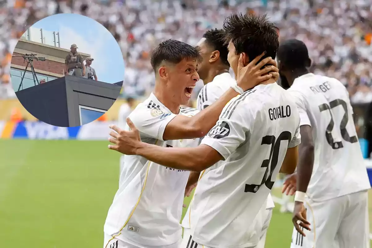 Jugadores de fútbol celebran un gol en el campo mientras en un recuadro se observa a personal de seguridad en la azotea de un edificio cercano.