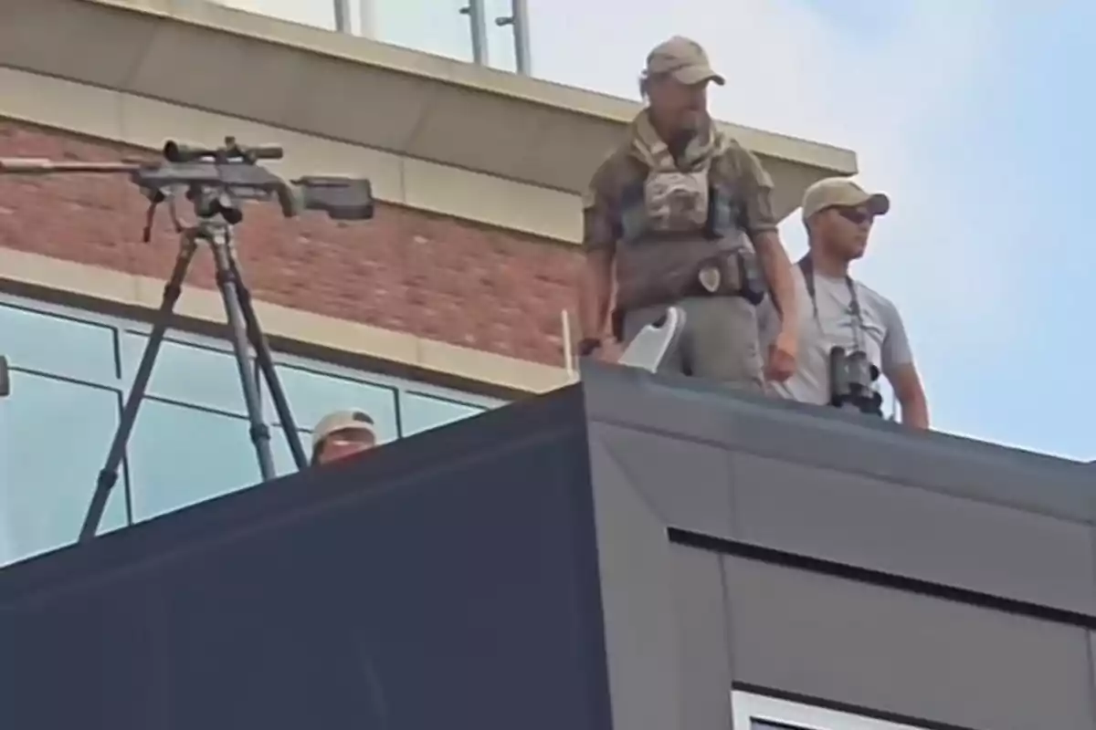 Snipers and security personnel on a building rooftop observing the area with a precision rifle mounted on a tripod Snipers and security personnel on a building rooftop observing the area with a precision rifle mounted on a tripod