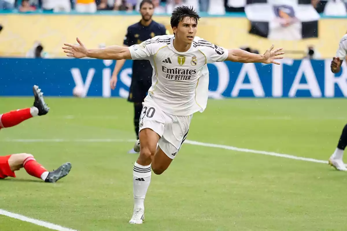 Real Madrid player celebrating a goal with arms outstretched during a match Real Madrid player celebrating a goal with arms outstretched during a match