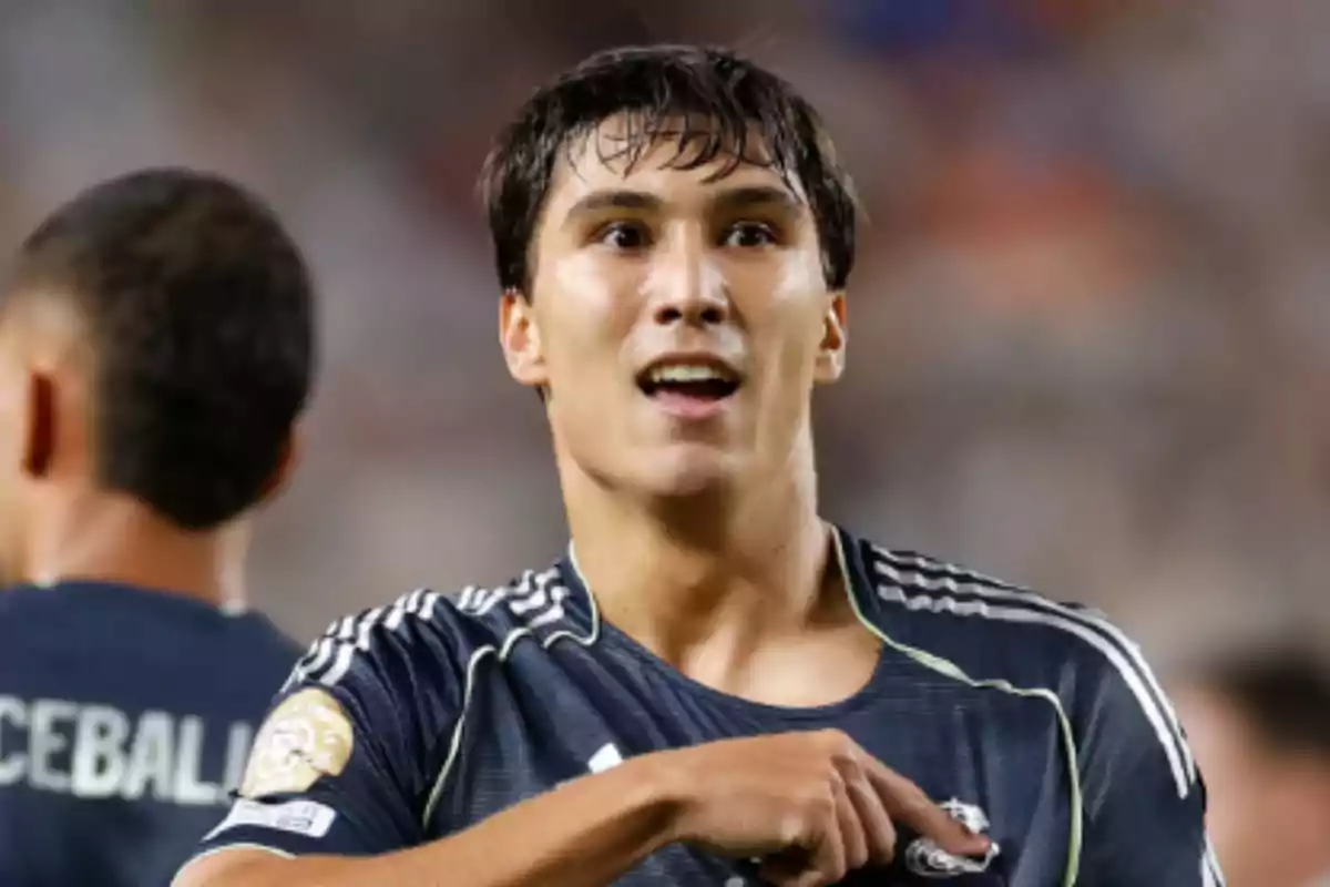 Soccer player celebrating a goal while pointing to the badge on his jersey during a match Soccer player celebrating a goal while pointing to the badge on his jersey during a match