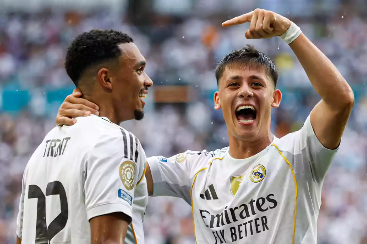 Two Real Madrid players celebrate a goal with smiles on the field during a match. Two Real Madrid players celebrate a goal with smiles on the field during a match.