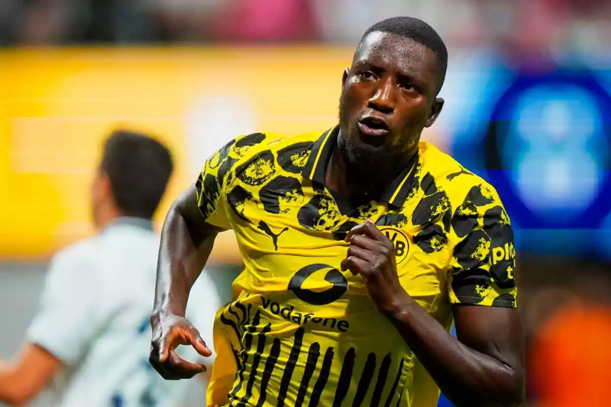 Futbolista del Borussia Dortmund celebrando un gol con el uniforme amarillo y negro del equipo durante un partido Futbolista del Borussia Dortmund celebrando un gol con el uniforme amarillo y negro del equipo durante un partido