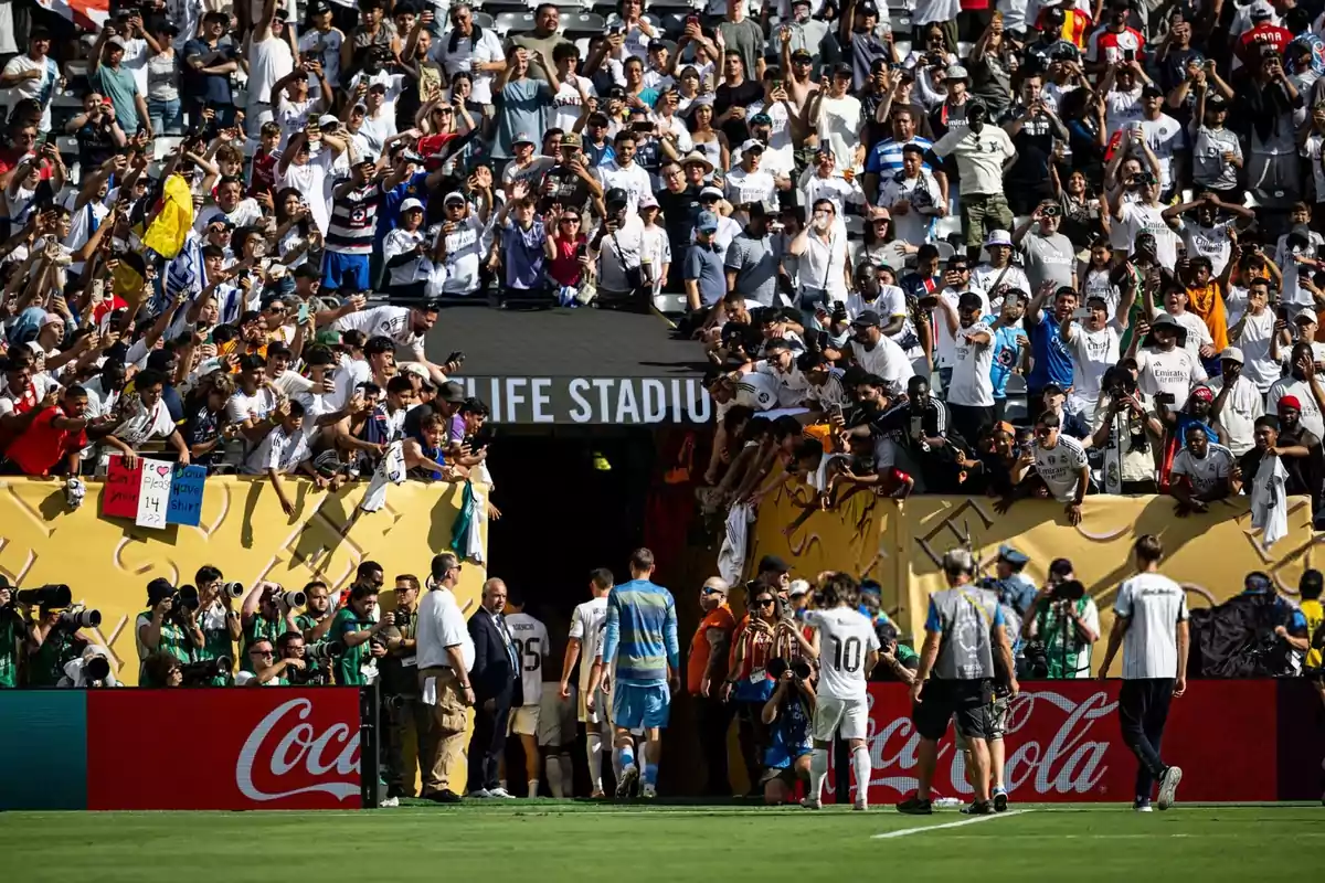 Fans cheer and take photos as the players head to the locker room in a packed stadium. Fans cheer and take photos as the players head to the locker room in a packed stadium.