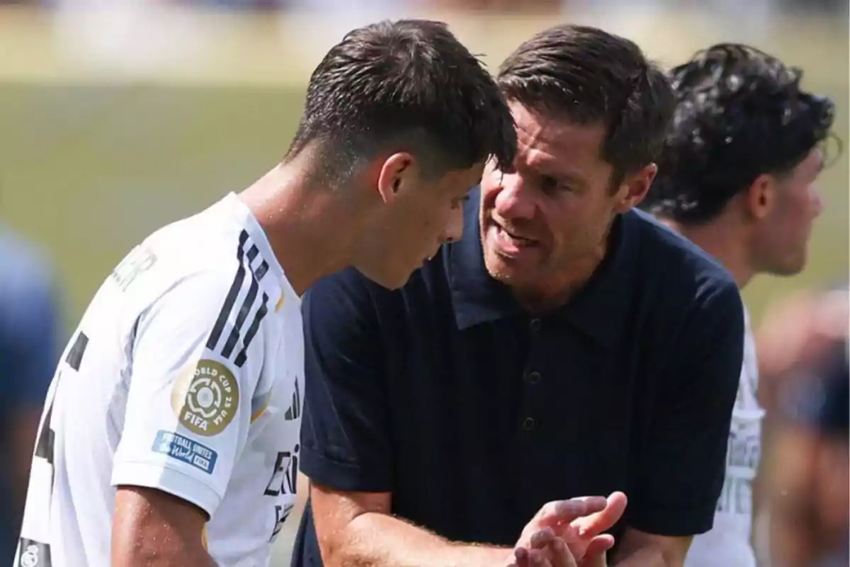 Entrenador de fútbol dando indicaciones a un joven jugador durante un partido Entrenador de fútbol dando indicaciones a un joven jugador durante un partido