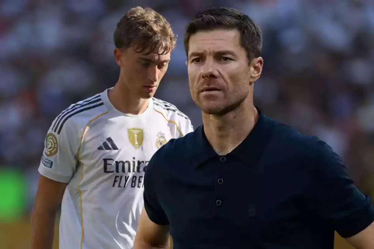 Dos hombres en primer plano, uno con camiseta blanca de fútbol del Real Madrid y otro con camisa oscura, ambos con expresión seria y fondo desenfocado de estadio.