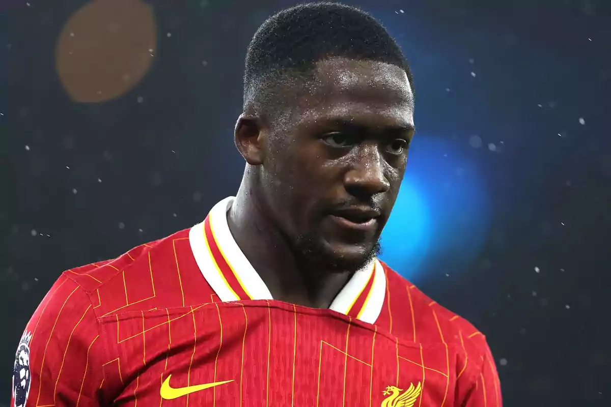 Futbolista con camiseta roja del Liverpool durante un partido bajo la lluvia Futbolista con camiseta roja del Liverpool durante un partido bajo la lluvia