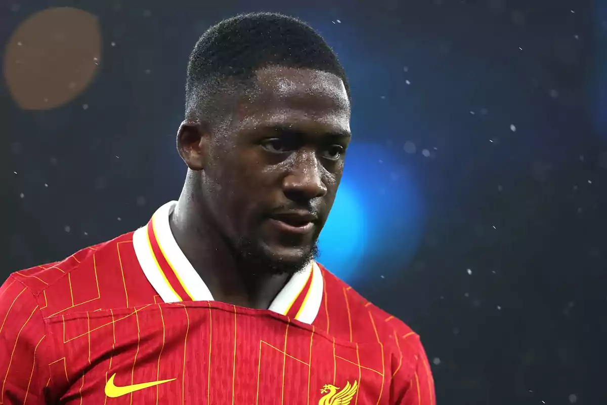 Futbolista con camiseta roja del Liverpool durante un partido bajo la lluvia Futbolista con camiseta roja del Liverpool durante un partido bajo la lluvia