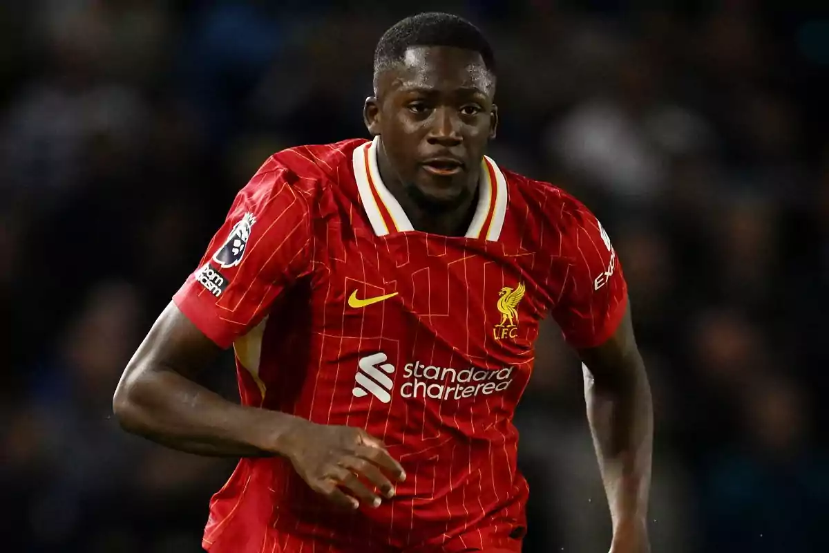 Soccer player in a red Liverpool uniform running on the field during a match Soccer player in a red Liverpool uniform running on the field during a match