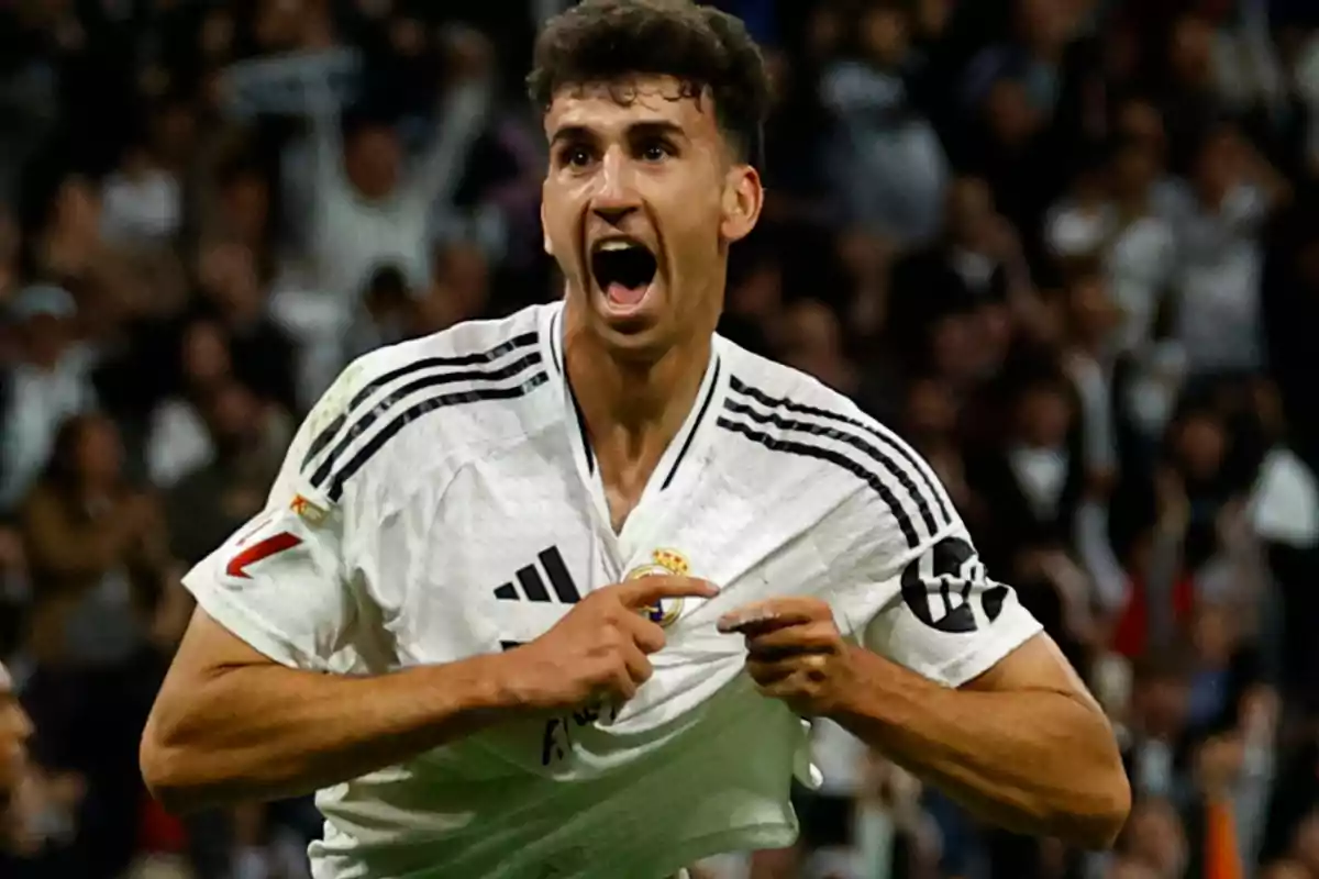 Soccer player celebrating a goal wearing the Real Madrid jersey in a stadium full of fans Soccer player celebrating a goal wearing the Real Madrid jersey in a stadium full of fans