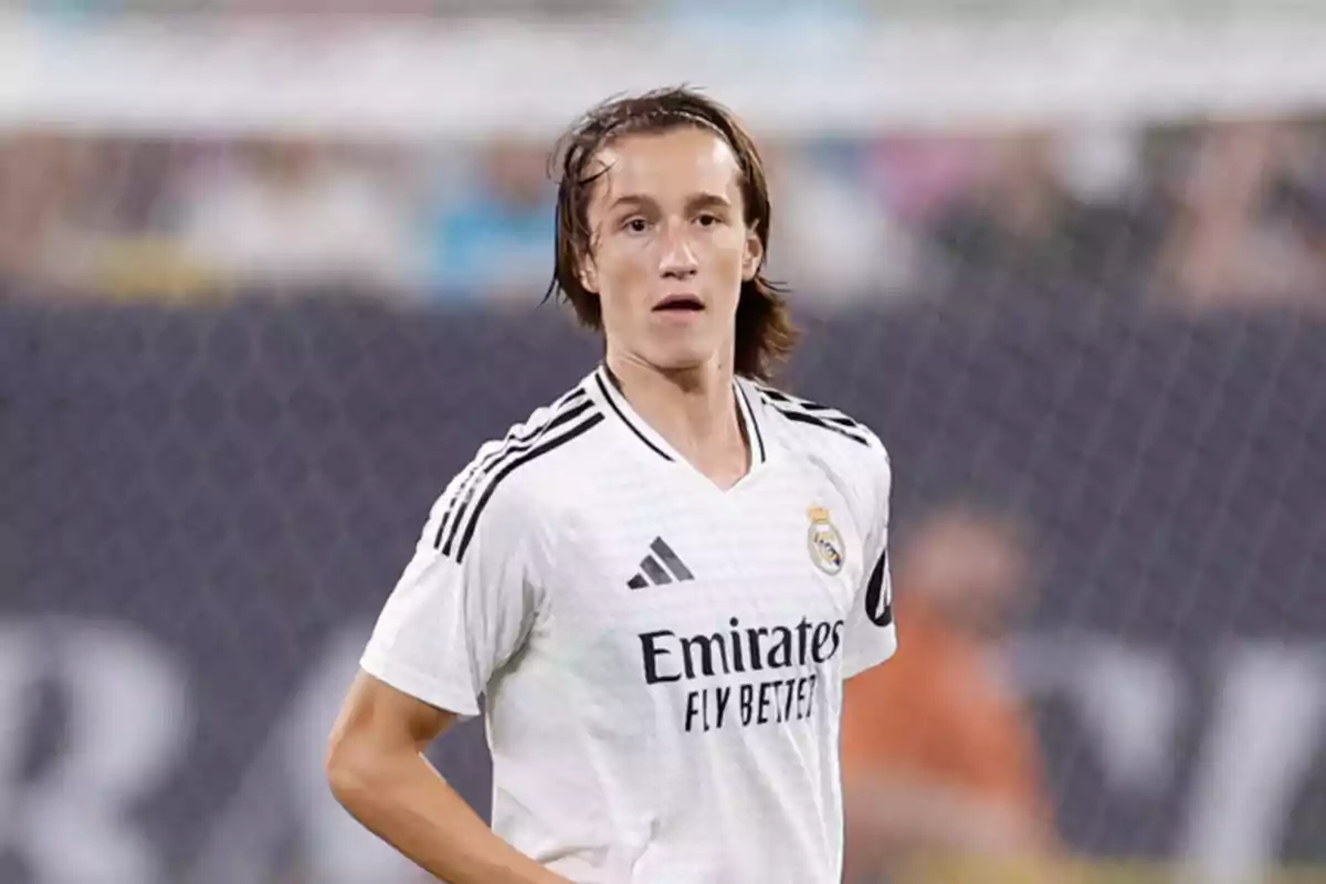 Soccer player wearing Real Madrid’s white uniform on the field during a match Soccer player wearing Real Madrid’s white uniform on the field during a match