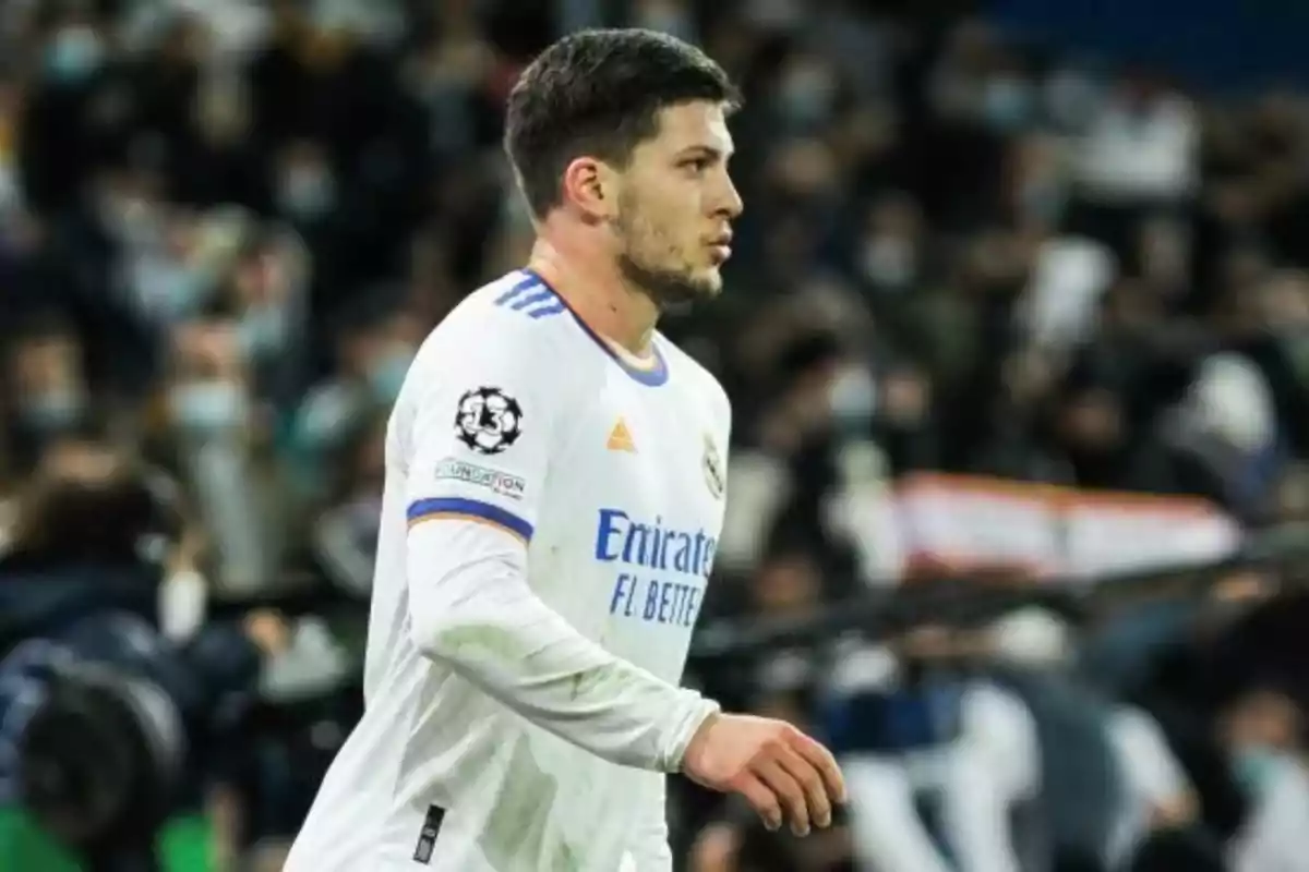 Futbolista con uniforme blanco del Real Madrid durante un partido con público en las gradas al fondo