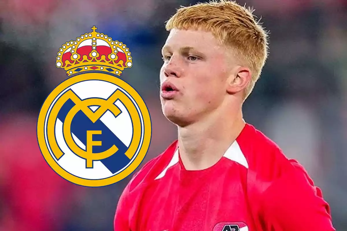 Joven futbolista rubio con camiseta roja junto al escudo del Real Madrid