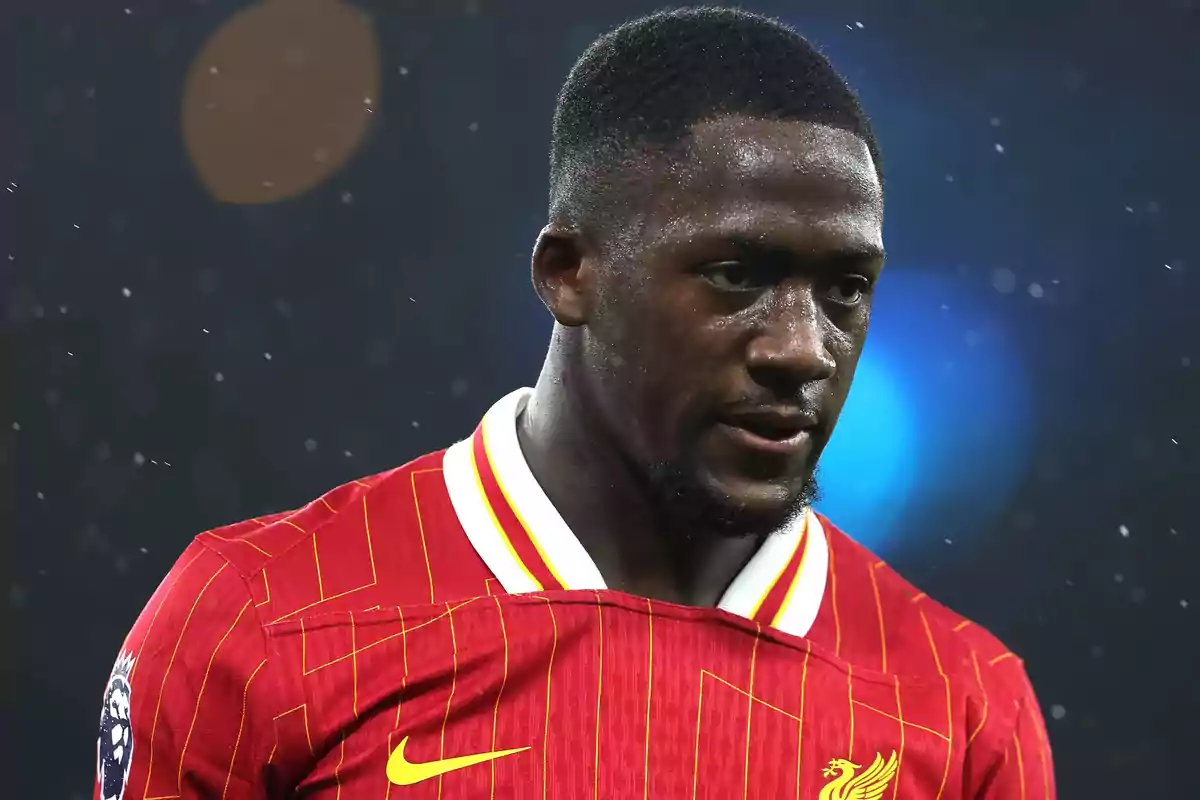 Futbolista con camiseta roja del Liverpool durante un partido bajo la lluvia Futbolista con camiseta roja del Liverpool durante un partido bajo la lluvia