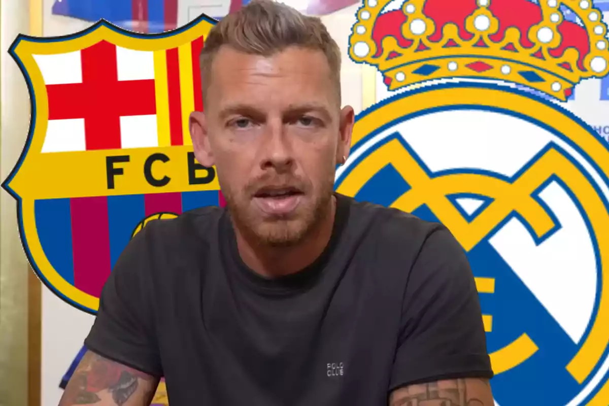 Hombre de cabello corto y barba con camiseta oscura sentado frente a los escudos del FC Barcelona y Real Madrid