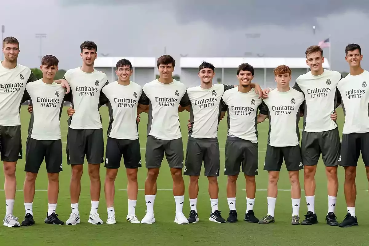 Eleven young players in Real Madrid training uniforms pose together on a grass field. Eleven young players in Real Madrid training uniforms pose together on a grass field.