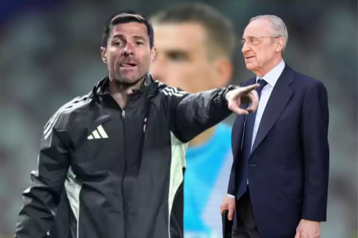 Soccer coach pointing while an older man in a suit watches him against a blurred stadium background
