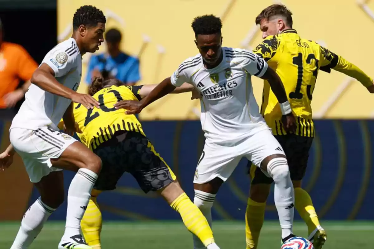 Real Madrid and Borussia Dortmund players fight for the ball during a soccer match. Real Madrid and Borussia Dortmund players fight for the ball during a soccer match.